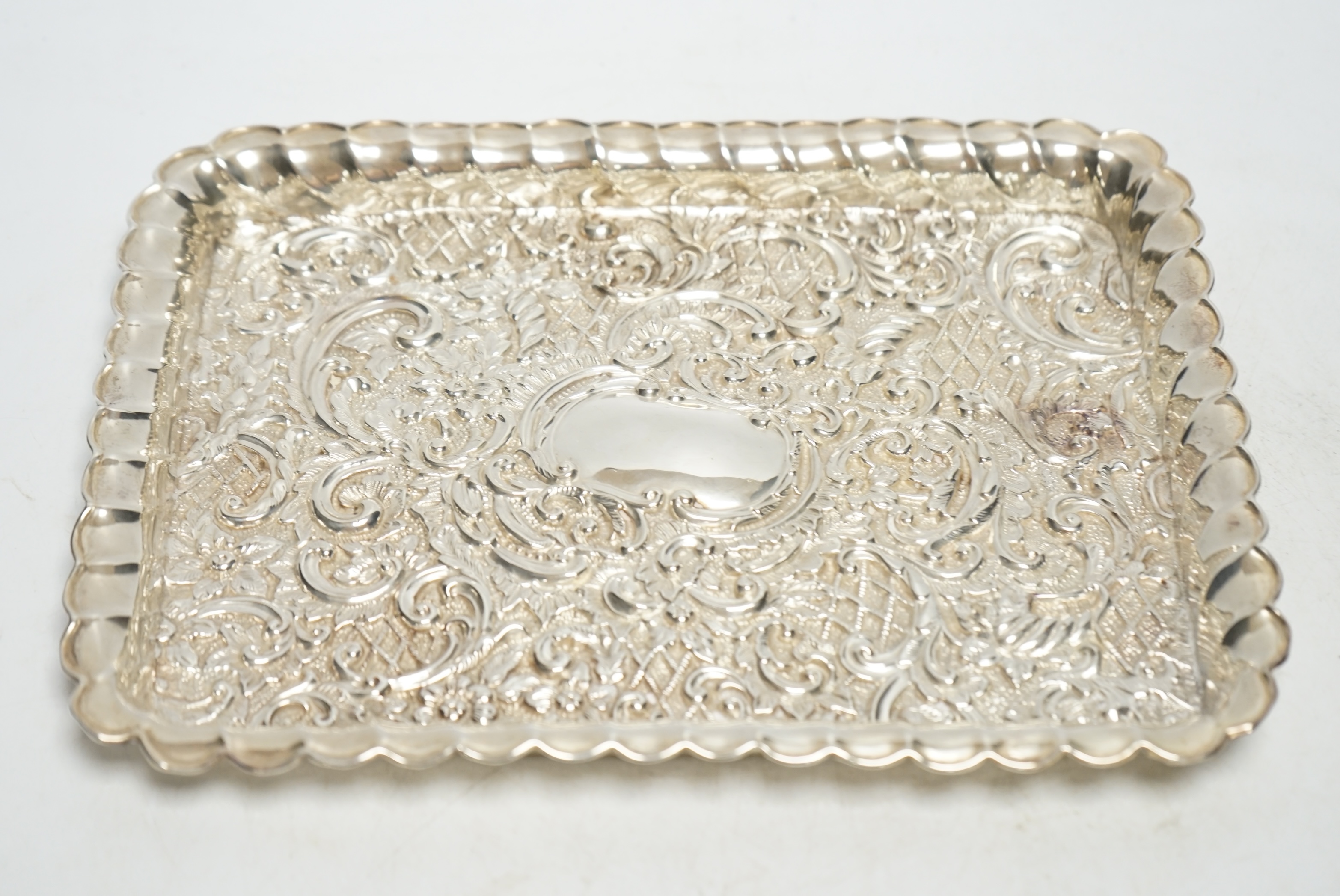 An Edwardian repousse silver dressing table tray, Henry Matthews, Birmingham, 1902, 24.6cm, 6.3oz. Condition - fair